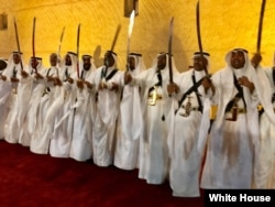 Saudi men, dressed in traditional garb and holding long swords aloft, perform a traditional war victory dance of the Nadj region. President Donald Trump and first lady Melania Trump walked past them into a small museum on the grounds of Murabba Palace in Riyadh, May 20, 2017. (Pool photo)