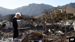 Marsha Maus, who has lived in the Seminole Springs Mobile Home Park for 15 years, looks through her charred belongings, NSunday,