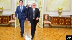 In this photo taken on Tuesday, Oct. 20, 2015, Russian President Vladimir Putin, right, and Syria President Bashar Assad arrive for their meeting in the Kremlin in Moscow, Russia. 