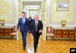 In this photo taken on Tuesday, Oct. 20, 2015, Russian President Vladimir Putin, right, and Syria President Bashar Assad arrive for their meeting in the Kremlin in Moscow, Russia.