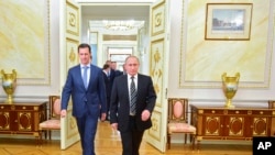 Russian President Vladimir Putin, right, and Syria President Bashar Assad arrive for their meeting in the Kremlin, Moscow, Oct. 20, 2015.