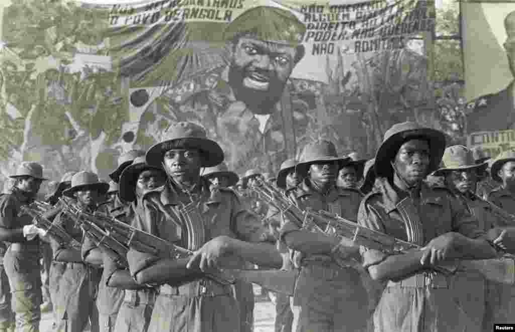 Guerrilheiros da UNITA marcham na frente da imagem de Jonas Savimbi