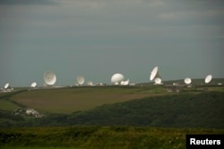 FILE - Satellite dishes are seen at GCHQ's outpost at Bude, close to where trans-Atlantic fiber-optic cables come ashore in Cornwall, southwest England, June 23, 2013.