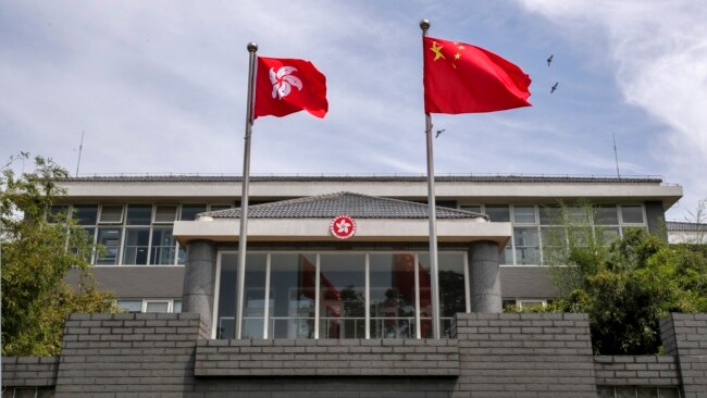 中国国旗和香港特区旗帜在港府办公楼前飘扬。（2020年6月30日）
