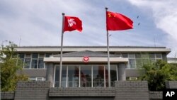 资料照：香港特区政府驻北京办事处前飘扬的中国国旗和香港旗帜。（2020年6月30日）