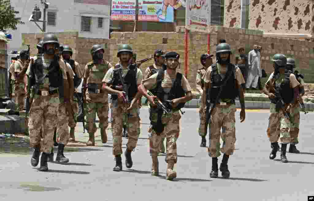 Security personnel inspect the site around a training center after gunmen attacked the facility in Karachi, Pakistan, June 10, 2014. 