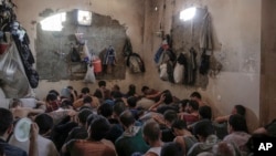 FILE - Suspected Islamic State members sit inside a small room in a prison south of Mosul, July 18, 2017. 