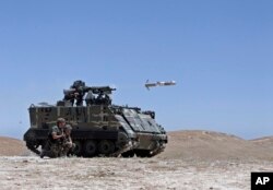 FILE - A Lebanese army vehicle fires a TOW-II missile in the village of Taybeh, near Baalbek, eastern Lebanon.