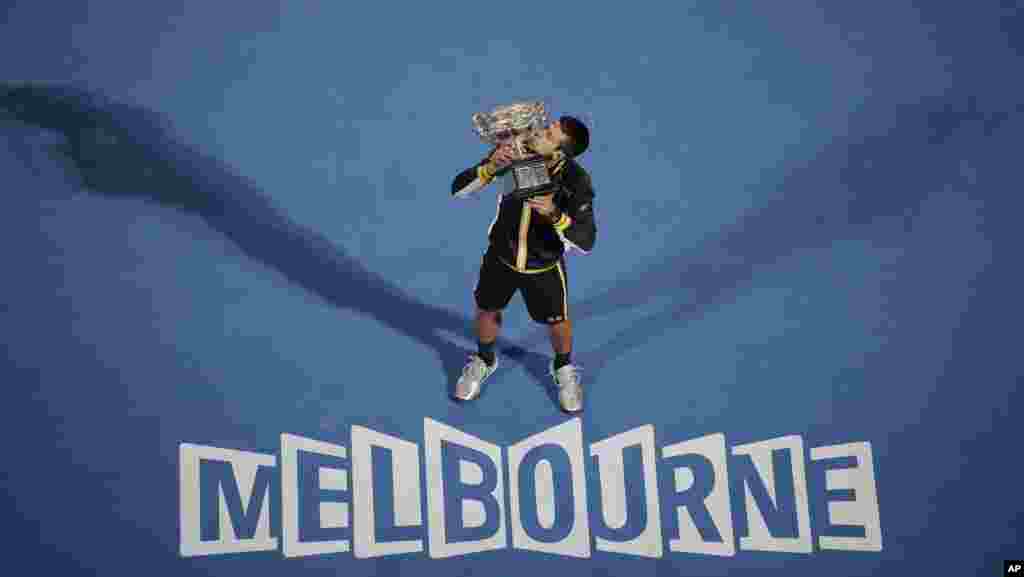 Serbia&#39;s Novak Djokovic kisses his trophy after defeating Britain&#39;s Andy Murray in the men&#39;s final at the Australian Open tennis championship in Melbourne, Australia.