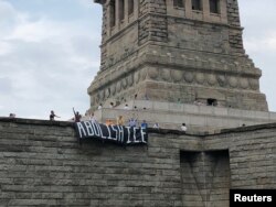 The group Rise and Resist stages a protest at the Statue of Liberty in New York, July 4, 2018, in this picture obtained from social media. (Rise and Resist/via Reuters)