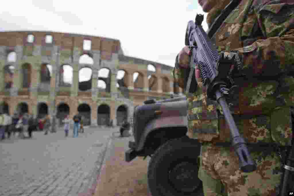 Một người lính Ý tuần tra gần Đấu trường Colosseum ở Rome. Những địa điểm như nhà thờ, giáo đường Do Thái, nhà hàng, rạp hát, khách sạn được xác định là &quot;những mục tiêu tiềm năng&quot; cho những vụ tấn công khủng bố ở hai thành phố Rome và Milan.