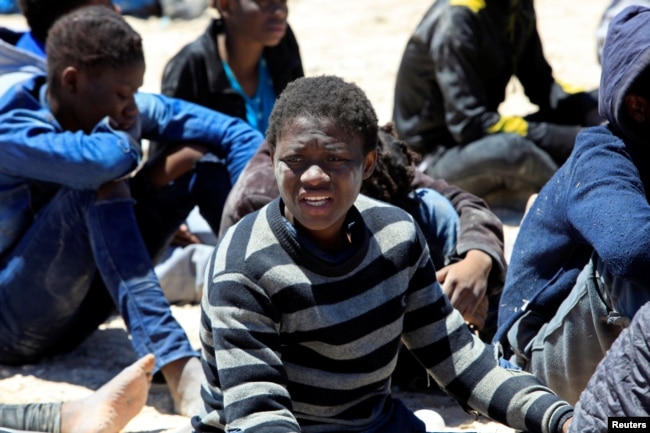 FILE - Migrants who'd attempted to flee to Europe wait in Libyan coast guard detention in the coastal city of Tripoli, Libya, May 16, 2016. The country's civil war has created openings for extremists, which Western governments hope to halt.