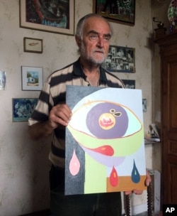 FILE - Pierre Pol Vincke poses with a painting by his daughter, Edith, in Ramillies, Belgium, June 26, 2017. Belgium is one of few countries that allow euthanasia but doctors refused his daughter's request despite years of psychiatric illness, and Edith eventually took her own life on Nov. 3, 2011.