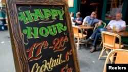 FILE - A happy hour sign is seen in front of a bar on the Grands Boulevards in Paris, France. 