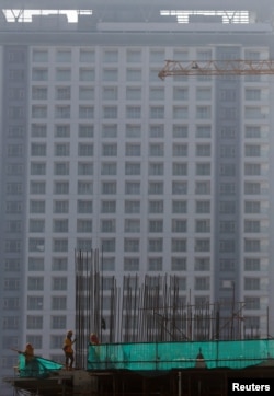 FILE - Labourers work at a construction site in Phnom Penh, Cambodia, June 3, 2019.