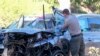 Seorang petugas penegak hukum memeriksa kendaraan yang rusak menyusul kecelakaan terguling yang melibatkan pegolf Tiger Woods, Selasa, 23 Februari 2021, di pinggiran Rancho Palos Verdes, Los Angeles. (Foto: AP)
