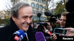 欧洲足联主席普拉蒂尼12月8日面带笑容抵达位于瑞士洛桑的体育仲裁法庭接受应讯。