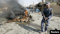 A policeman stands guard at the site of a bomb attack in Kirkuk, 250 kilometers north of Baghdad, July 23, 2012.