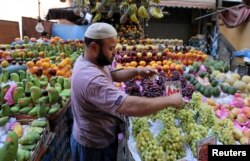 FILE - An Egyptian fruit seller works in a market in Cairo, June 15, 2016.