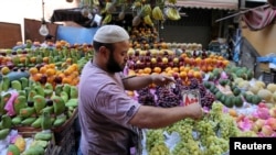 FILE - An Egyptian fruit seller works in a market in Cairo, June 15, 2016.