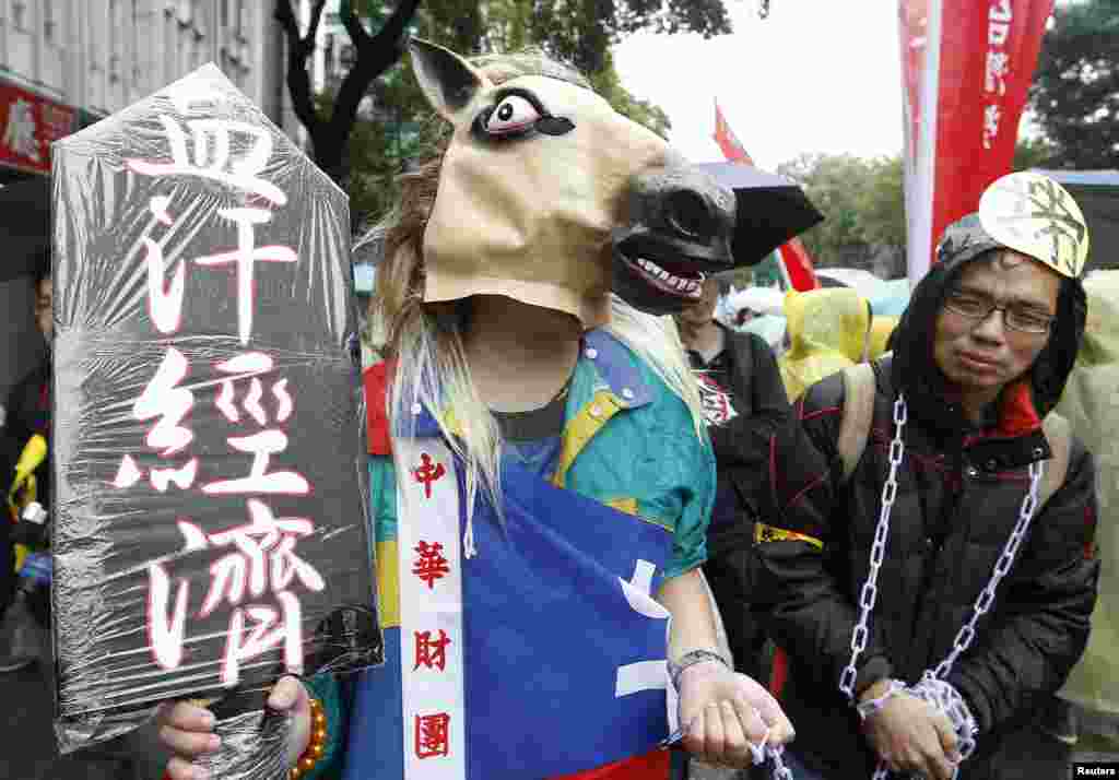 노동절을 맞이한 1일 타이완 수도 타이페이에서 말 모양의 가면과 쇠고랑을 차고 시위하는 근로자들.