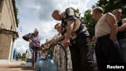 Residents collect water at a pumping station in the eastern Ukranian city of Slaviansk, June 17, 2014. Slaviansk, the pro-Russian separatist stronghold, is faced with ongoing shortages, utility outages and frequent artillery fire. 