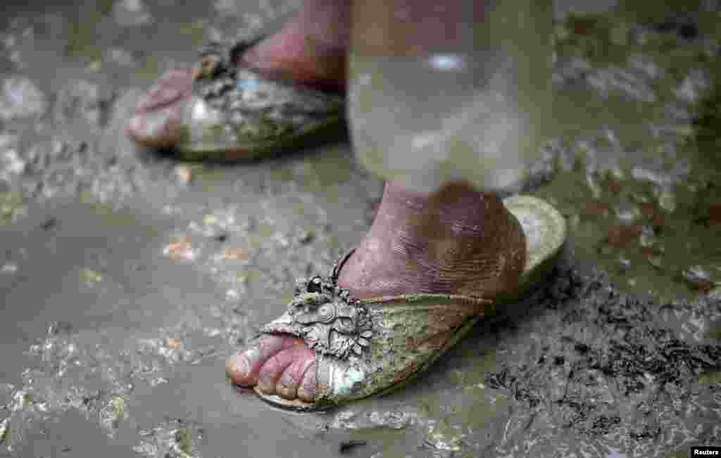 An internally displaced Syrian girl stands in the mud after heavy rain at a camp on the outskirts of Azaz, Syria.