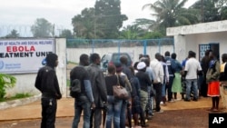 Liberian health workers queue to enter one of the largest Ebola treatment units at the Island Clinic Monrovia, Liberia. Oct. 13, 2014.