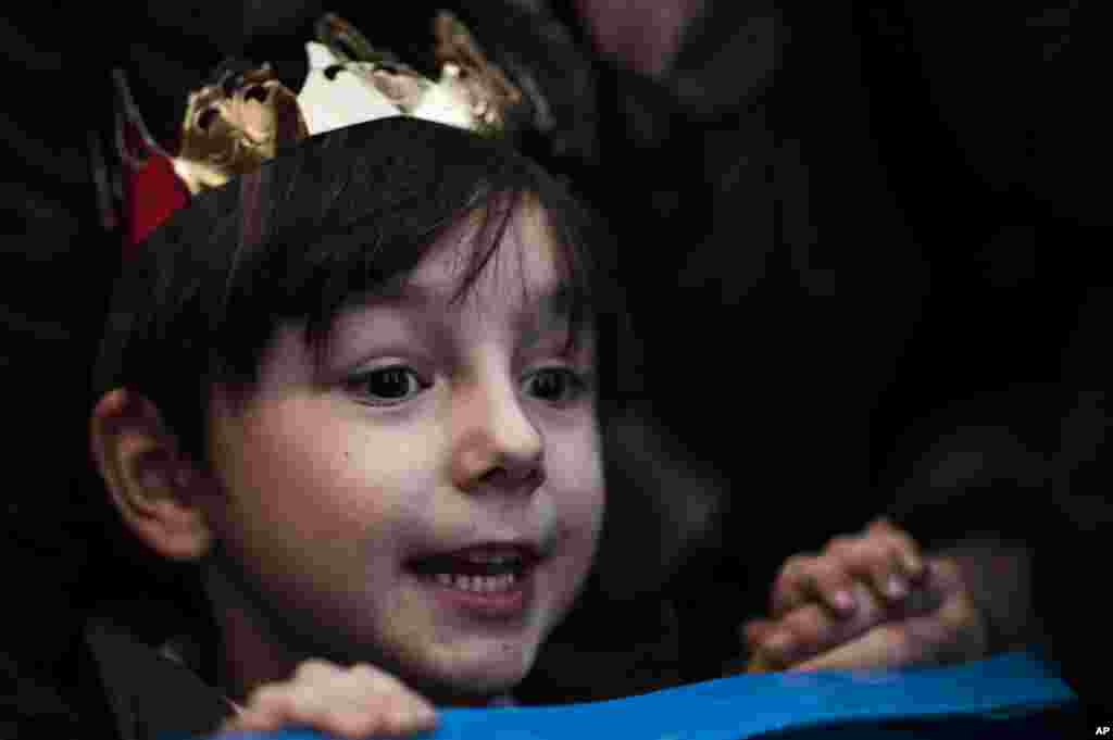 Un niño usa una corona mientras observa la Cabalgata de los Reyes Magos en la víspera de la Epifanía, en Pamplona, España.