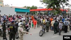 Cambodians gather outside a convenience store where political analyst Kem Ley was gunned down, Sunday July 09, 2016, Phnom Penh, Cambodia. (Leng Len/VOA Khmer)