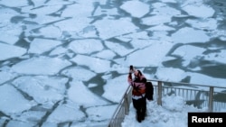 A pedestrian stops to take a photo by Chicago River, as bitter cold phenomenon called the polar vortex has descended on much of the central and eastern United States, in Chicago, Illinois, U.S., January 29, 2019.