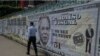 Un hombre pasa junto a carteles que muestran al ministro de Economía de Brasil, Paulo Guedes, en un billete de 9,55 millones de dólares, en Sao Paulo, Brasil, el 8 de octubre de 2021, pocos días después de que fuera mencionado en la investigación Los papeles de Pandora.