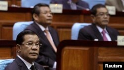 Prime Minister Hun Sen (L) attends a meeting at the National Assembly in central Phnom Penh September 24, 2013. Hun Sen is approved on Tuesday by Cambodia's parliament for a new 5-year term. REUTERS/Samrang Pring (CAMBODIA - Tags: POLITICS) - RTX13X8N