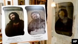 FILE - View of the deteriorated version of 'Ecce Homo' mural by 19th century painter Elias Garcia Martinez, right, next to a copy of the original, left, at the Borja Church in Zaragoza, Spain, Wednesday, March 16, 2016. An attempt to restore the original fresco did not turn out well. (AP Photo/Javier Vinuela)