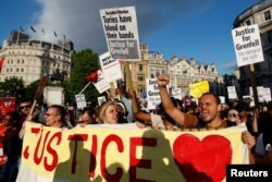 Demonstrators hold up banners during a march in Westminster, following the fire that destroyed The Grenfell Tower block, in north Kensington, West London, Britain, June 16, 2017.