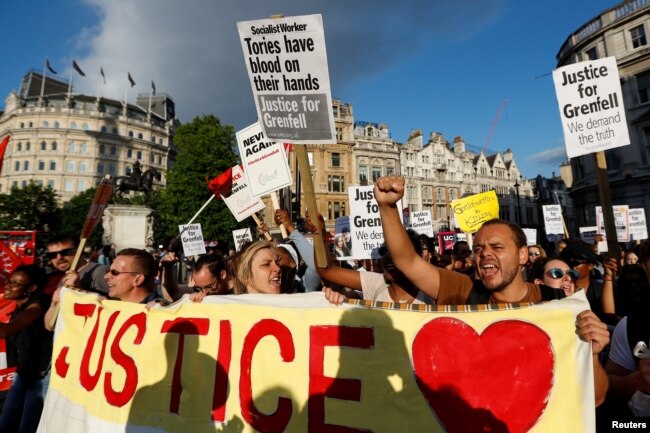 Demonstrators hold up banners during a march in Westminster, following the fire that destroyed The Grenfell Tower block, in north Kensington, West London, Britain, June 16, 2017.