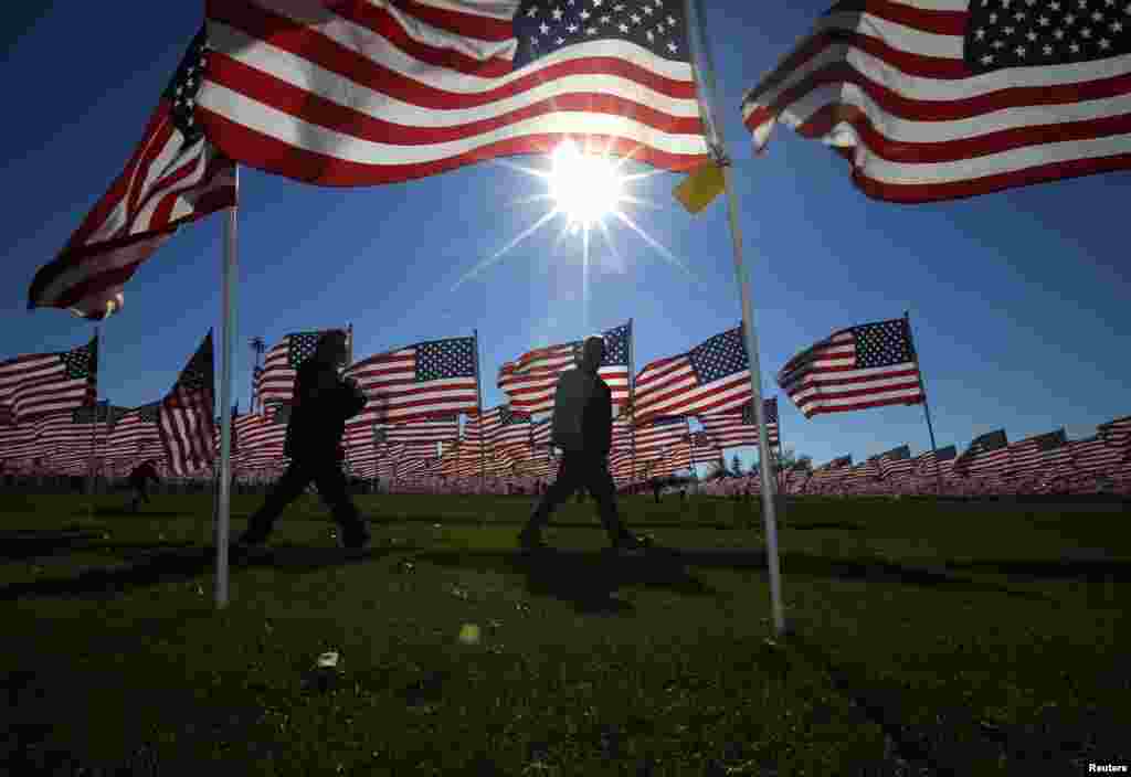 A couple walks through some of the two thousand and thirteen United States flags, that are part of the Aurora Healing Fields to honor veterans, during Veterans Day weekend, Aurora, Illinois, Nov., 10, 2013.