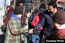 Kazi Mannan distributes food to the needy at a local food and coat drive -- one of many he organizes every year. (K.Mannan)