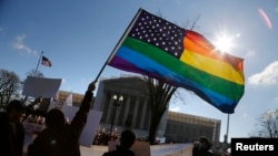 FILE - Gay rights activists wave rainbow flag in front of the U.S. Supreme Court in Washington.