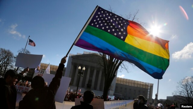FILE - Gay rights activists wave rainbow flag in front of the U.S. Supreme Court in Washington.
