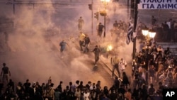 Demonstran di Athena, Yunani bentrok dengan polisi yang menembakkan gas air mata dalam protes menentang kenaikan pajak dan pemotongan anggaran pemerintah (foto: dok). 