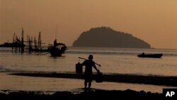 A fisherman carries fresh water to his fishing boat on Nyuang Wee Islandin Mergui Archipelago, Burma. The archipelago is thought by scientists to harbor some of the world’s most important marine biodiversity.