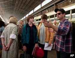 Center left to right: Joel Courtney (as Joe Lamb) and Riley Griffiths (as Charles) discuss a scene with director/writer/producer J.J. Abrams on the set of SUPER 8, from Paramount Pictures.