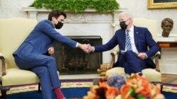 2021年11月18日，美国总统拜登在白宫椭圆形办公室与加拿大总理特鲁多举行双边会晤时与他握手。（法新社）。