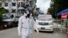 PPE ဝတ်စုံဝတ် ပရဟိတလုပ်သားတဦးကို ရန်ကုန်မြို့ရှိ လမ်းတခုမှာ တွေ့ရ။ (အောက်တိုဘာ ၁၂၊ ၂၀၂၀)