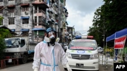 ရန်ကုန်မြို့ရှိ ရပ်ကွက်တခုမှာတွေ့ရတဲ့ PPE ဝတ်စုံပြည့် ပရဟိတ လုပ်သားတဦး။ (အောက်တိုဘာ ၁၂၊ ၂၀၂၀)