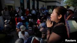 A protester cries in front of the U.S embassy after others were detained by security guards during an attempt to deliver a petition to the embassy in Phnom Penh, Cambodia, Jan. 21, 2014.