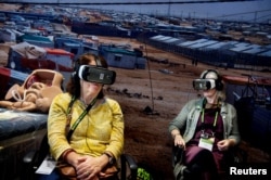 FILE - Participants watch virtual reality movie "Born into Exile", about two pregnant women who are due to deliver in Za'atari refugee camp, Jordan, during Women Deliver, a major women's health and rights conference in Copenhagen, Denmark, May 17, 2016.