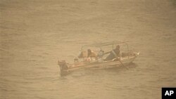 An Egyptian fisherman in his boat on the Nile river, during a dust storm in Cairo, Egypt, Dec 12, 2010