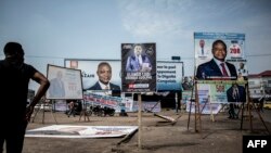 FILE - A man looks at campaign posters in the district of Lingwala in Kinshasa, DRC, Dec. 18, 2018.